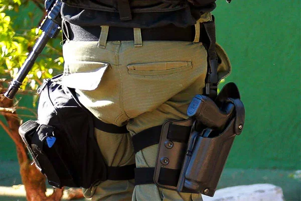 Imagem colorida de policial segurando armamento - Metrópoles