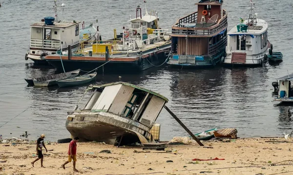 Imagem colorida de rio com baixo volume e ribeirinhos em Manaus (AM) - Metrópoles
