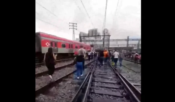 foto colorida de passageiros da CPTM caminhando pelos trilhos. perto da estação Brás, após falha na Linha 11-Coral - Metrópoles