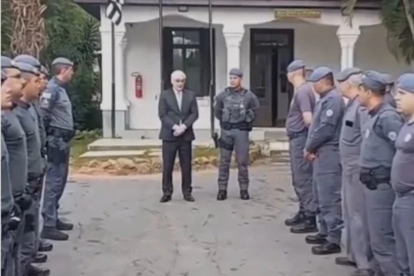 Homem de cabelo branco e terna em meio a policiais militares fardados - Metrópoles