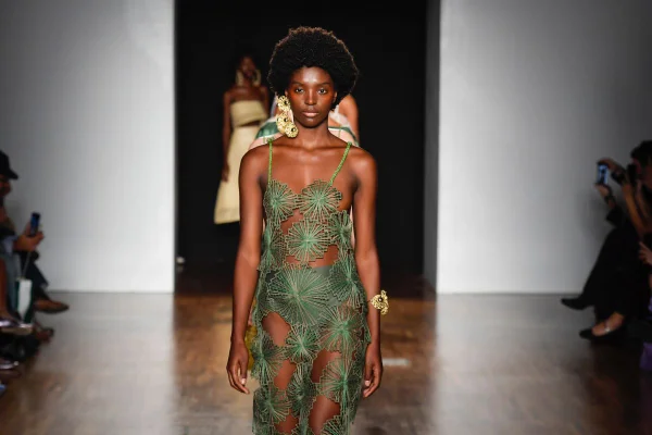 Modelo usando vestido verde na passarela de semana de moda - Metrópoles