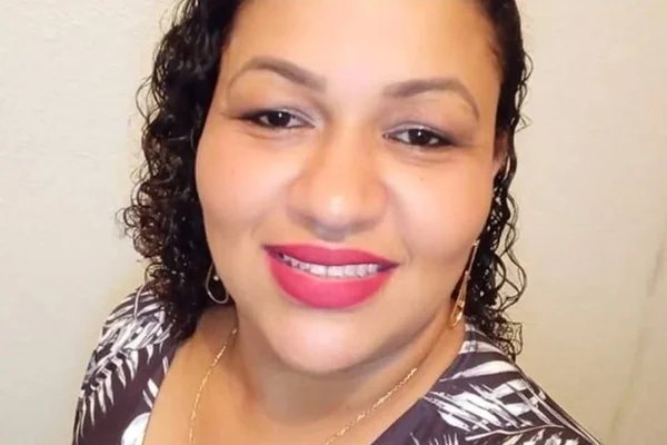 Mulher negra de cabelos cacheados e com batom rosa - Metrópoles