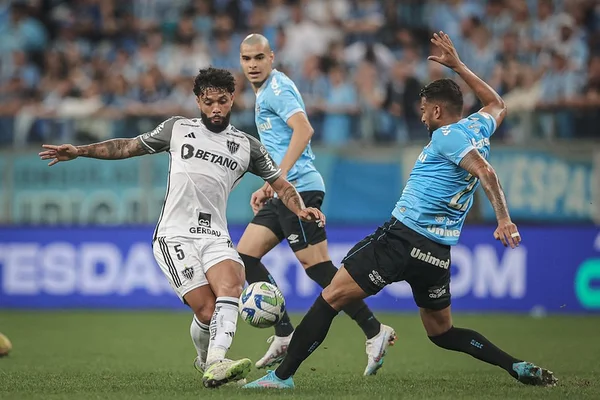 Foto colorida mostra jogadores de Atlético Mineiro e Grêmio durante partida - Metrópoles