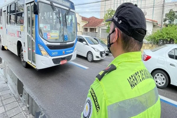 Imagem colorida, agente de trânsito sinalizando - Metrópoles