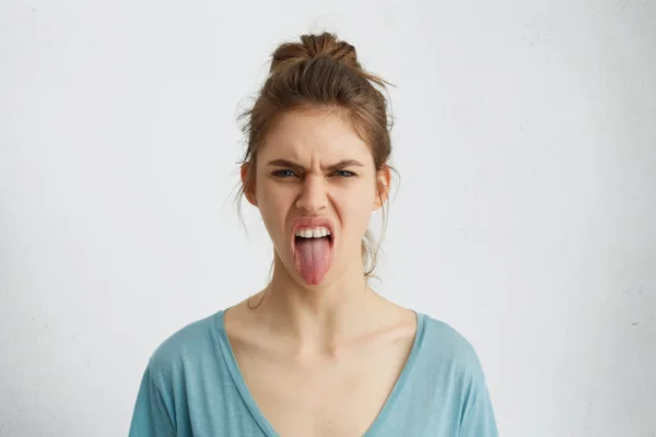 Mulher de mal humor com a língua para fora