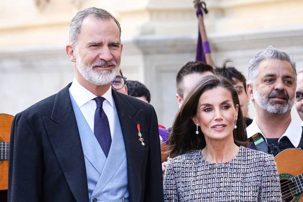 Foto colorida de homem com barba e usando terno ao lado de mulher com roupa de tweed - Metrópoles