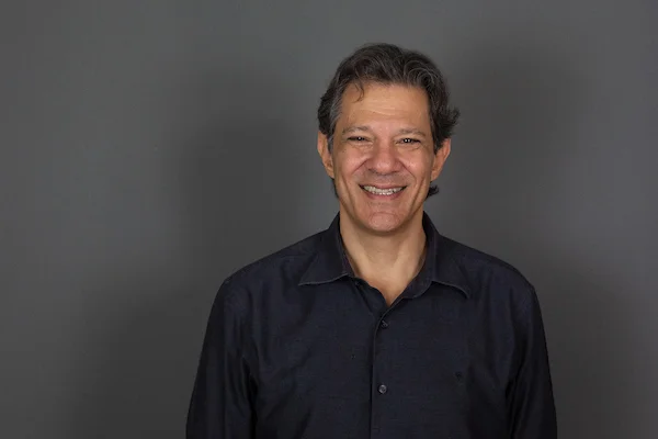 O pré-candidato ao governo de São Paulo, Fernando Haddad (PT), concede entrevista ao Metrópoles. Ele sorri sob fundo cinza - Metrópoles