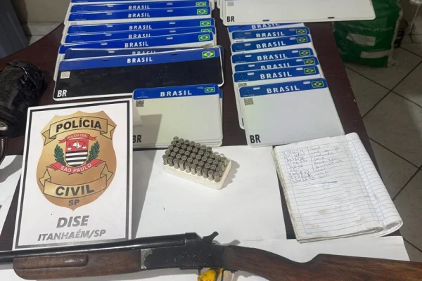 Imagem colorida de placas e materiais apreendidos em cima da mesa. Metrópoles