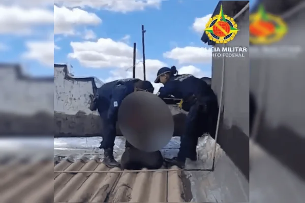 Foto colorida de homem preso no telhado