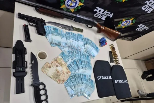 Foto colorida de uma espingarda calibre 12, uma pistola 9mm e munições apreendidas pela polícia - Metrópoles