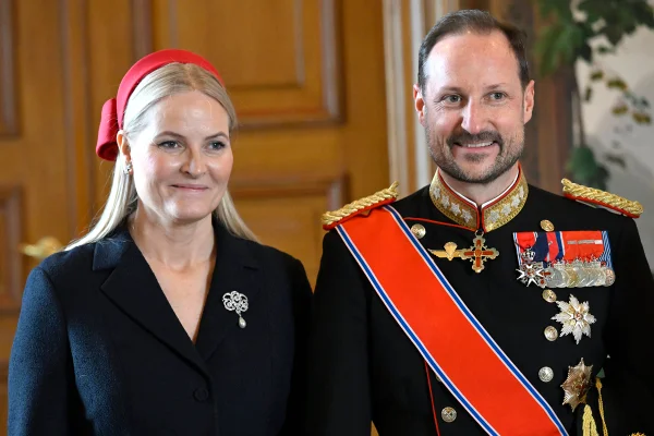 Foto colorida de mulher loira com roupa preta ao lado de homem com traje militar - Metrópoles - Haakon