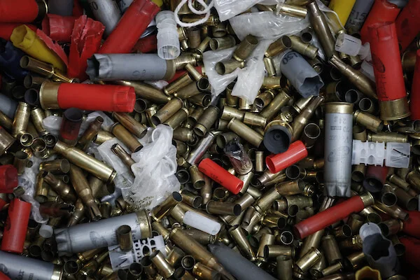 Diversas munições de diferentes armas de fogo aparecem jogadas uma por cima da outra, com cartuchos vazios. A maioria é dourada ou vermelha - Metrópoles