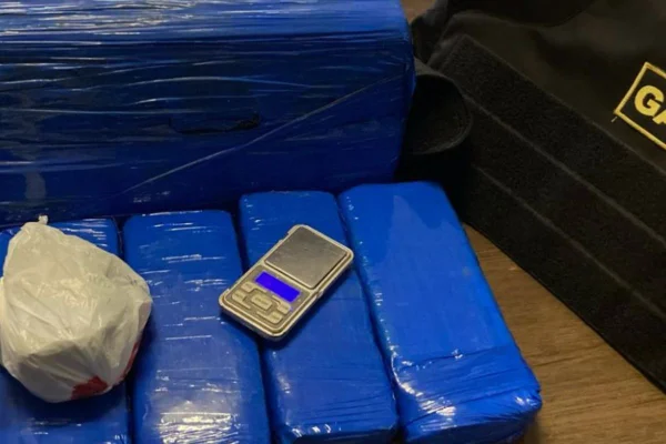 Imagem colorida de droga apreendida em operação do MPSP e da PM contra o PCC. Entorpecentes estão embalados com fita azul, sobre uma mesa - Metrópoles