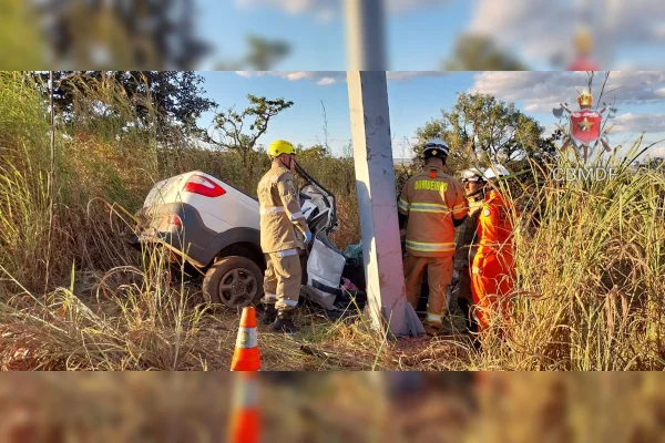 Foto colorida de acidente de carro em poste fora da pista