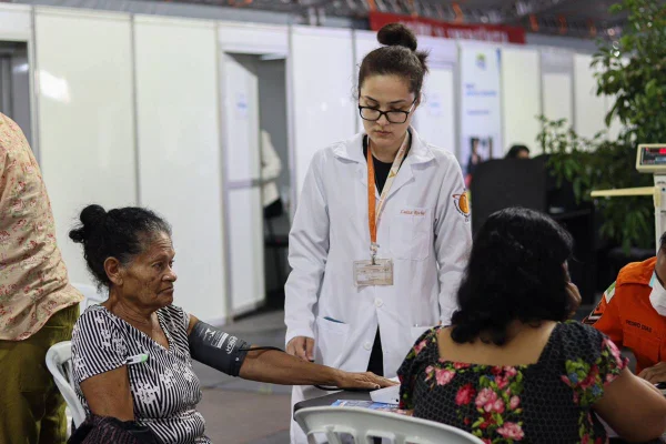 Foto colorida de médica fazendo aferindo pressão