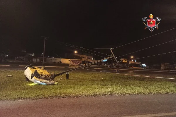 Carro capotado atinge poste de tensão que cede e cai na pista