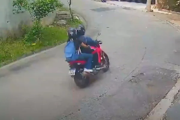 Imagem colorida de homem levando jovem na garupa de moto em rua - Metrópoles