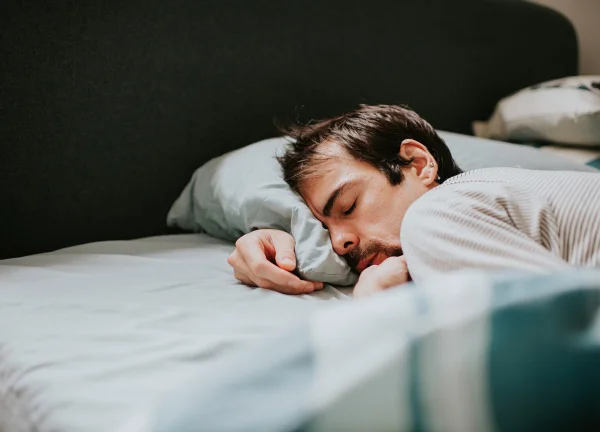 Homem dormindo em cama - Metrópoles