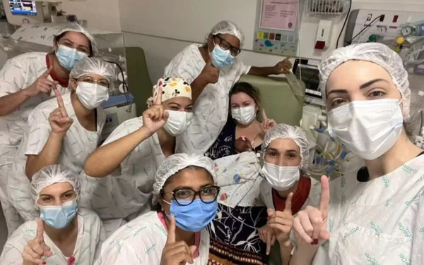 Imagem colorida de equipe médica com bebê que nasceu prematura - Metrópoles