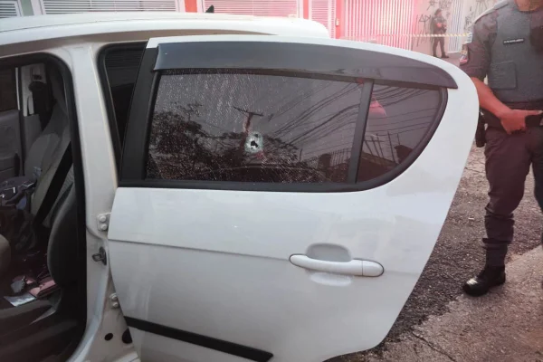 Foto colorida de carro branco, com perfuração no vidro traseiro - Metrópoles