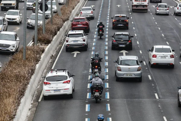 Imagem colorida mostra via expressa com carros circulando e motos andando em uma faixa azul pintada no asfalto; sinalização está na 23 de Maio, na Faria Lima e em outras avenidas - Metrópoles