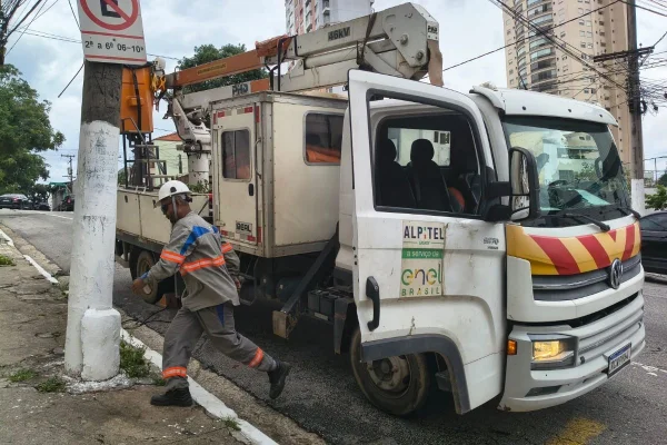 Imagem colorida mostra funcionários da Enel após apagão em SP. Metrópoles