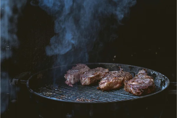 Carnes sendo assada em churrasqueira