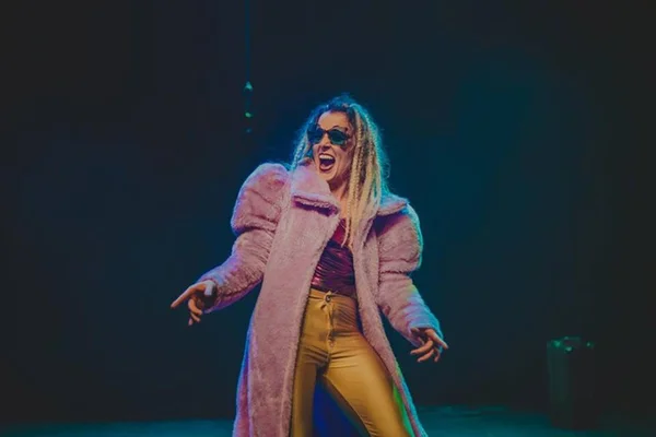 foto colorida de uma mulher com casaco rosa