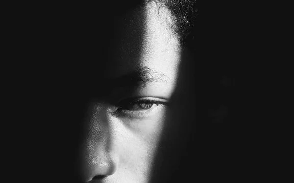 Homem na sombra com luz no rosto