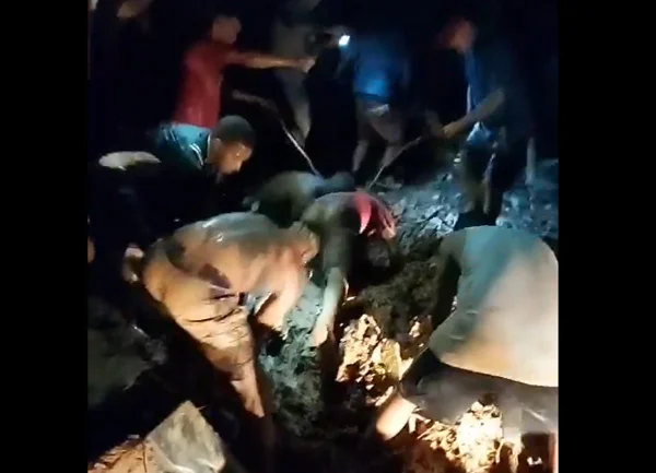 Imagem colorida de moradores procurando pessoas soterradas após casa desabar em Japeri, no Rio de Janeiro depois de chuvas - Metrópoles