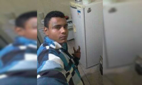 Jovem de casaco azul, sorrindo para foto