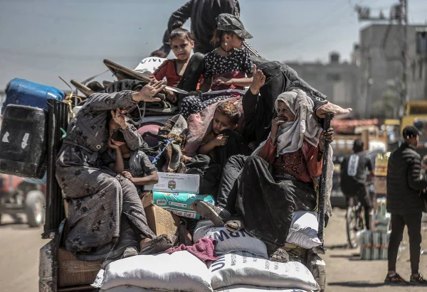 Imagem colorida mostra mulheres e crianças palestinas em uma carroceria de um caminhão fugindo de Rafah - Metrópoles