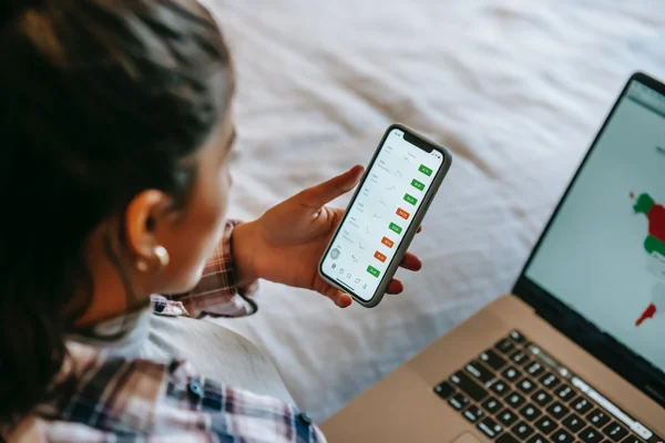 Mulher de frente para celular e computador - Metrópoles