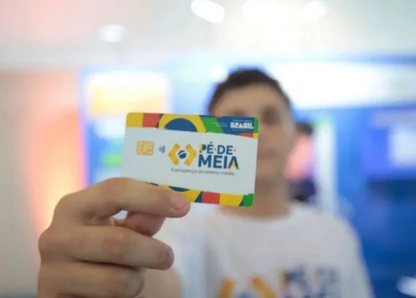 Beneficiária do programa Pé-De-Meia mostrando o cartão