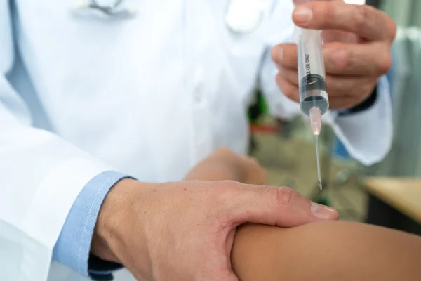 Médico com uma seringa para dar em injeção para paciente - Metrópoles