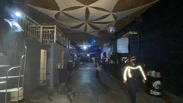 Policiais andando em espaço onde ocorria festa clandestina