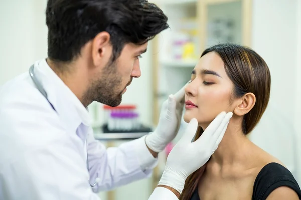 Médico analisando rosto de paciente mulher