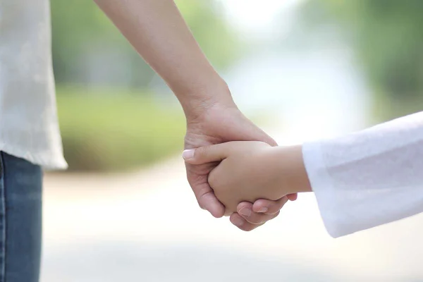 Mãe andando de mãos dadas com sua filha