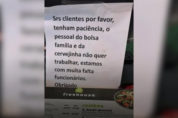 Imagem colorida de um comunicado escrito em papel na bancada de atendimento de um restaurante - Metrópoles