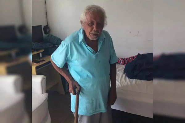 Idoso com camisa azul e bengala na mão