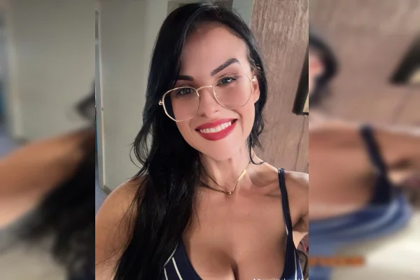 Imagem colorida de uma mulher branca, de óculos, cabelos lisos e roupa preta