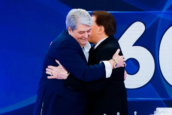 Os apresentadores Datena e Sílvio Santos se abraçam durante Jogo dos Pontinhos - Metrópoles