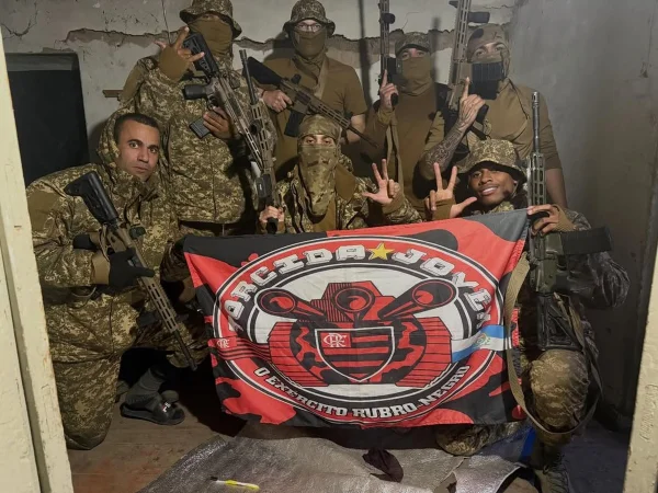 Imagem colorida mostra brasileiros na Ucrânia com a bandeira da Torcida Jovem do Flamengo - Metrópoles