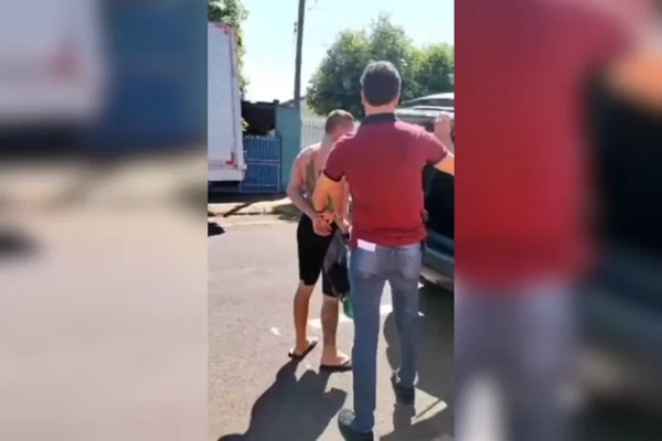 Imagem colorida de um homem sem camisa sendo preso na viatura da polícia - Metrópoles