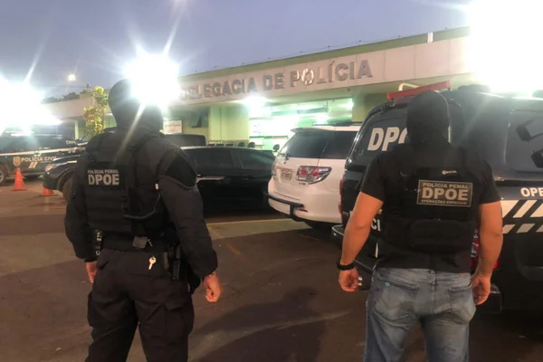 policiais em frente à delegacia