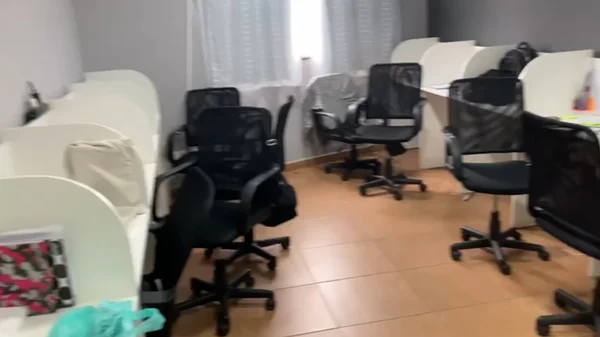 Cadeiras espalhadas em uma sala com baias - Metrópoles