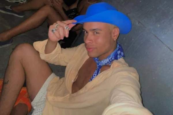 Imagem de homem negro com camisa rosa e chapéu azul - Metrópoles