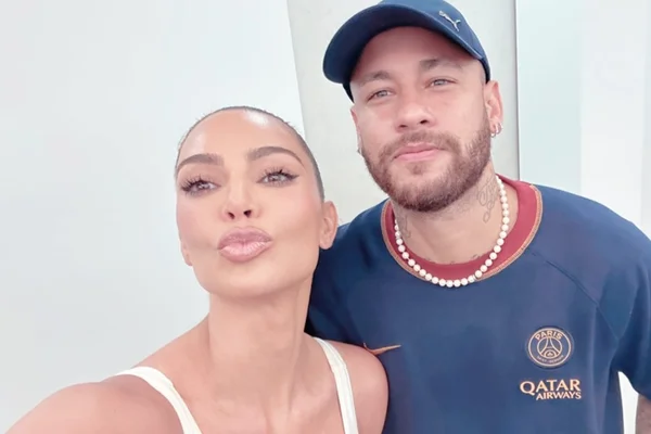 Neymar está com a camisa do PSG e um colar, enquanto Kim Kardashian está com uma camisa de alcinha branca - Metrópoles