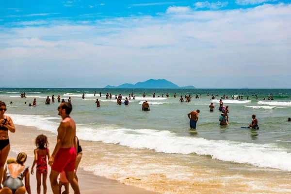 Foto colorida de banhistas em praia do litoral de Santa Catarina - Metrópoles