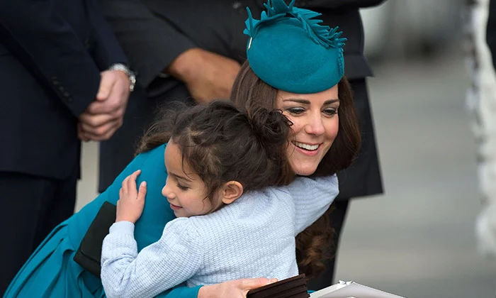A duquesa de Cambridge compartilha um abraço com uma garotinha no aeroporto de Dunedin durante sua visita à Nova Zelândia, em 2014 A duquesa de Cambridge compartilha um abraço com uma garotinha no aeroporto de Dunedin durante sua visita à Nova Zelândia, em 2014